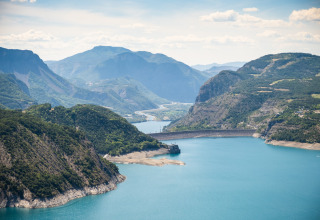 Udsigt over søen og bjergene ved Huttopia Lac de Serre Ponçon feriested, Provence-Alpes-Côte d’Azur, Frankrig.