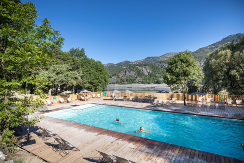 Piscina al aire libre con vistas al lago y montañas en Huttopia Lac de Serre Ponçon, Provenza-Alpes-Costa Azul.