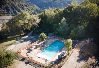 Luchtfoto van zwembad en bomen bij vakantiepark Huttopia Lac de Serre Ponçon in de Franse Alpen regio.