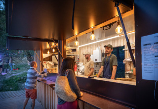 Eetstand bij Huttopia Lac de Serre Ponçon met bezoekers en medewerkers in Provence-Alpes-Côte d’Azur, Frankrijk.