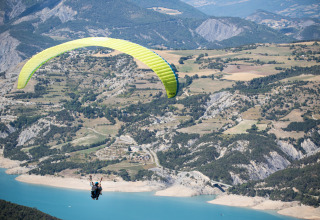 Paragliding above the scenic landscapes around Ubaye-Serre-Ponçon in Provence-Alpes-Côte d’Azur, France.