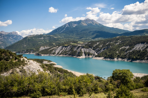 Gebirgslandschaft und blauer See nahe Ubaye-Serre-Ponçon in Provence-Alpes-Côte d’Azur, Frankreich bei Sonne.