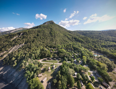 Vista aérea de colinas arboladas y cabañas cerca de Ubaye-Serre-Ponçon, Provenza-Alpes-Costa Azul, Francia.