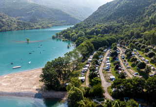 Luchtfoto van een camping aan het meer bij Ubaye-Serre-Ponçon, omgeven door bossen en bergen in Frankrijk.