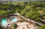 Aerial view of pools, playground, and greenery at Huttopia Chardons Bleus - Ile de Ré holiday park in France.