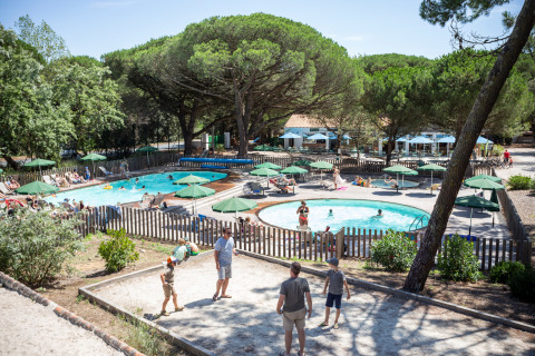 Piscina y huéspedes en el parque vacacional Huttopia Chardons Bleus - Ile de Ré, Nouvelle-Aquitaine, Francia.