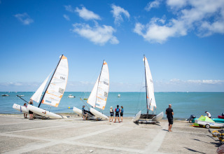 Velisti preparano i catamarani sulla spiaggia di Huttopia Chardons Bleus - Ile de Ré, Nouvelle-Aquitaine, Francia.