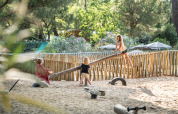 Kinder spielen auf einer Wippe auf dem Sandspielplatz im Huttopia Chardons Bleus - Ile de Ré, Frankreich.