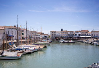Boten aangemeerd in een charmante haven met witte gebouwen in Sainte-Marie-de-Ré, Nouvelle-Aquitaine.