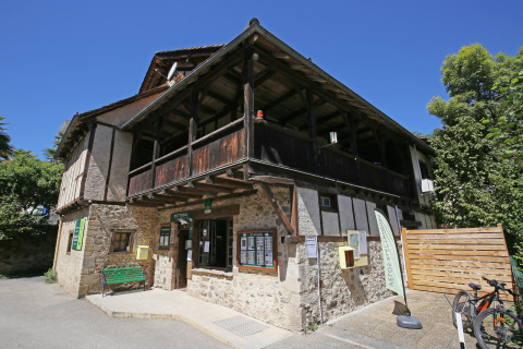 Authentiek stenen gebouw bij Huttopia Beaulieu sur Dordogne vakantiepark, Occitanië, Frankrijk, onder blauwe lucht.