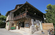 Edificio in pietra nel villaggio vacanze Huttopia Beaulieu sur Dordogne, Occitania, Francia, sotto cielo azzurro.