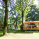 Mobile home Vancouver at Huttopia Beaulieu sur Dordogne in France, surrounded by lush green trees outdoors.