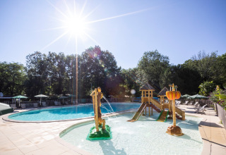 Udendørs swimmingpool med børneområde og solrige omgivelser på Huttopia Beaulieu sur Dordogne i Occitanie.