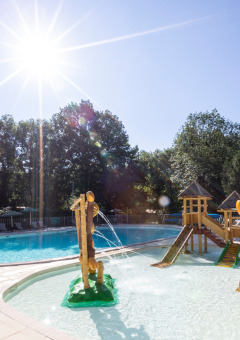 Außenpool mit Kinderbereich und Sonnenschein im Huttopia Beaulieu sur Dordogne in Occitanie, Frankreich.