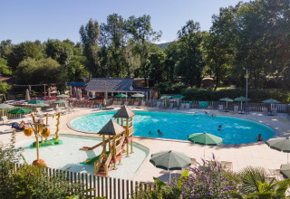 Piscina all'aperto e area giochi d'acqua per bambini con scivoli a Huttopia Beaulieu sur Dordogne in Francia.