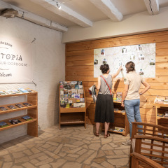 Zwei Personen betrachten eine Karte in der Rezeption des Huttopia Beaulieu sur Dordogne Ferienparks, Frankreich.