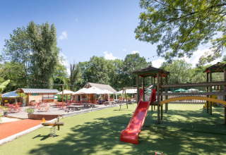 Legeplads og udendørs caféområde ved Huttopia Beaulieu sur Dordogne feriepark i Occitanie, Frankrig.
