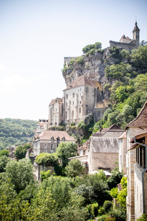 Middeleeuwse gebouwen en een kloosterkapel tegen de rots bij Beaulieu-sur-Dordogne, Occitanië, Frankrijk.