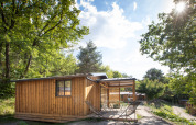 Holzhütte Chalet Evasion mit Terrasse im Grünen bei Huttopia Lac de Serre Ponçon in Frankreich.