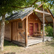 Træhytte ved navn Montana chalet Vista omgivet af træer, med veranda og picnicbord i skyggen.