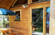 Terraza de madera y exterior del Montana chalet Vista en Huttopia Lac de Serre Ponçon, Francia.