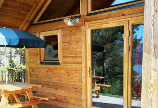 Terraza de madera y exterior del Montana chalet Vista en Huttopia Lac de Serre Ponçon, Francia.