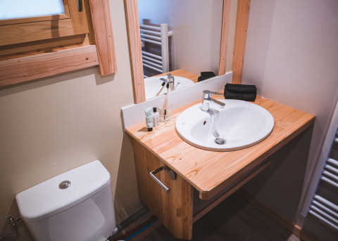 Bagno del Montana chalet Vista a Huttopia Lac de Serre Ponçon, Francia, con lavabo, specchio e finestra.