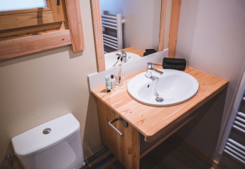 Bagno del Montana chalet Vista a Huttopia Lac de Serre Ponçon, Francia, con lavabo, specchio e finestra.