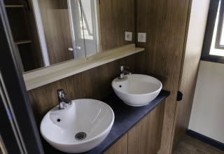 Moderne badeværelse med dobbelt håndvask i Chalet Portland, Huttopia Lac de Serre Ponçon, Frankrig.
