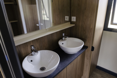 Baño moderno con dos lavabos en el Chalet Portland de Huttopia Lac de Serre Ponçon, Francia.