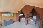 Indvendigt af en safari bungalow telt Classic ved Huttopia Vallouise i Frankrig med to enkeltsenge.