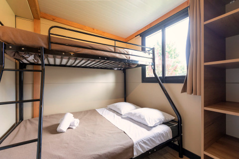 Kamer met stapelbed en groot raam in het glampingverblijf Mobile home Vancouver, licht en gezellig.