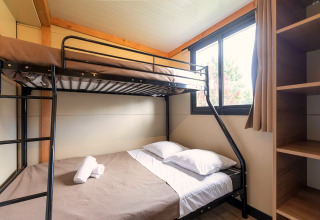 Kamer met stapelbed en groot raam in de glamping accommodatie Mobile home Vancouver, licht en gezellig.