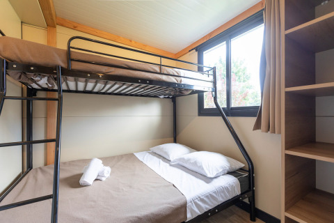 Værelse med køjeseng og vindue i glamping boligen Mobile home Vancouver, lyst og hyggeligt indrettet.