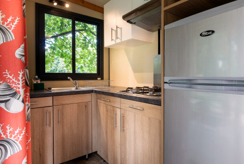 Moderne keuken in een Mobile home Vancouver glampingverblijf met houten kasten en gasfornuis.