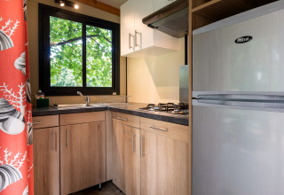 Moderne keuken in een Mobile home Vancouver glamping accommodatie met houten kasten en gaskookplaat.