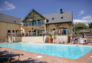 Zwembad en ontspanningszone bij Camping Seasonova Saint Michel, een vakantiepark in Normandië, Frankrijk.