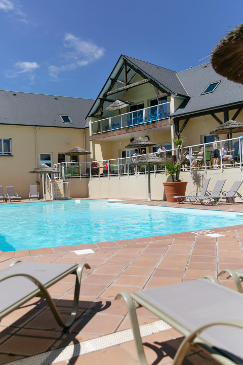 Außenpool und Sonnenliegen im Camping Seasonova Saint Michel Ferienpark in der sonnigen Normandie, Frankreich.