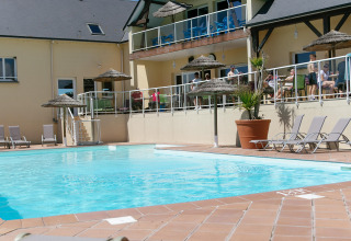 Swimmingpool og liggestole på Camping Seasonova Saint Michel feriepark i solrige Normandiet, Frankrig.