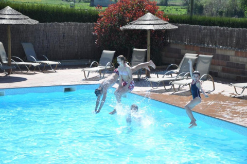 Kinder springen in einen Pool im Camping Seasonova Saint Michel, einem Ferienpark in der Normandie, Frankreich.