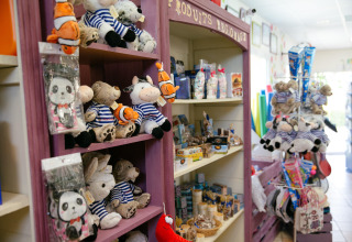 Negozio di giocattoli e souvenir al Camping Seasonova Saint Michel, Normandia, con peluche e dolci sugli scaffali.