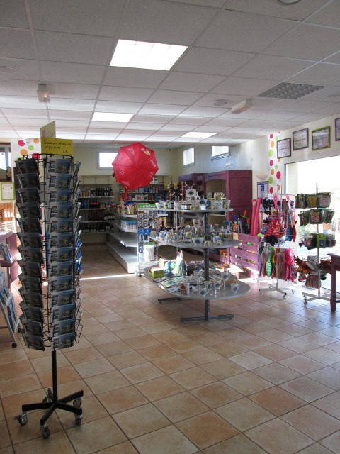 Interior de la tienda en Camping Seasonova Saint Michel con souvenirs, postales y productos en Normandía, Francia.