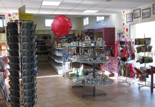 Intérieur du magasin du Camping Seasonova Saint Michel avec souvenirs, cartes postales et produits en Normandie.