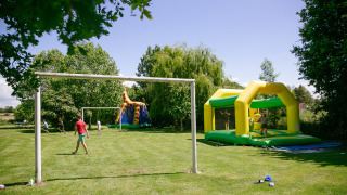 Niños juegan al fútbol y disfrutan de un castillo inflable en Camping Seasonova Saint Michel, Normandía, Francia.