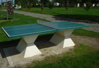 Tischtennisplatte im Freien auf einer Wiese im Camping Seasonova Saint Michel in der Normandie, Frankreich.