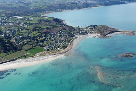 Vista aérea del Camping Seasonova Les 7 Iles en Bretaña, Francia, mostrando costa y parque vacacional.