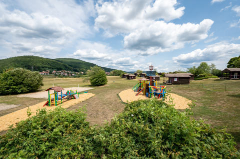 Parque infantil y cabañas en Camping Seasonova Les Vosges du Nord en la región Grand Est de Francia.