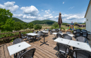 Udendørs terrasse med borde og stole på Camping Seasonova Les Vosges du Nord, Grand Est, Frankrig.