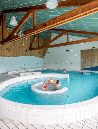Piscina cubierta con huéspedes en Camping Seasonova Les Vosges du Nord, parque vacacional en Grand Est, Francia.