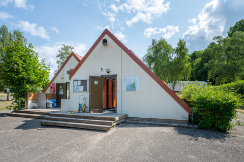 Toiletgebouw op Camping Seasonova Les Vosges du Nord, omgeven door natuur en bomen, Grand Est, Frankrijk.